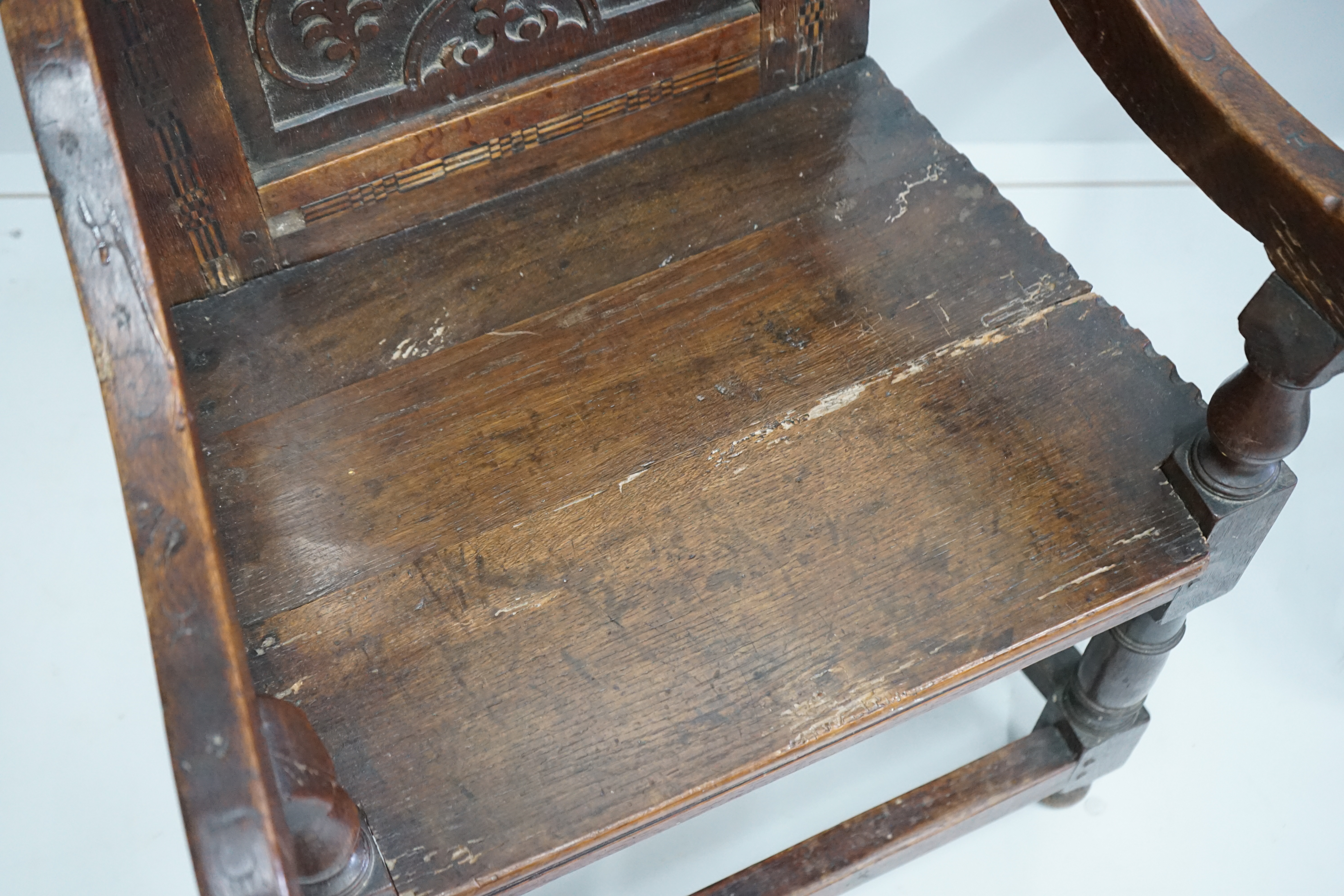 A pair of 17th century style inlaid panelled oak wainscot chairs, width 57cm, depth 40cm, height 121cm